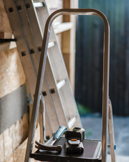 A closeup shot of a hummer and tools on the stairs during the house construction